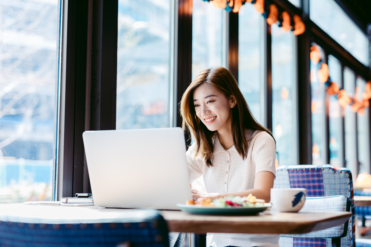 Asian woman working laptop at cafe.